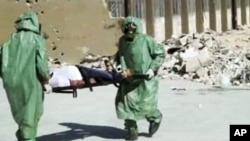 FILE - People in protective suits and gas masks conducting a drill on how to treat casualties of a chemical weapons attack in Aleppo, Syria.