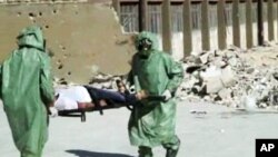 FILE - People in protective suits and gas masks conduct a drill on how to treat casualties of a chemical weapons attack in Aleppo, Syria. Islamic State fighters reportedly fired rockets loaded with mustard gas into a town north of Baghdad late Tuesday and early Wednesday. 
