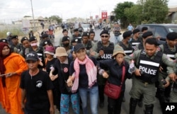 Cambodian civil rights supporters are forcibly directed by riot police as they march in protest of charges brought against local rights activists near Prey Sar prison, outside Phnom Penh, Cambodia, May 9, 2016.
