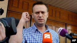 Russian opposition leader Alexei Navalny speaks to the media at the headquarters of the Russian Investigation committee in Moscow, Russia, June 12, 2012.