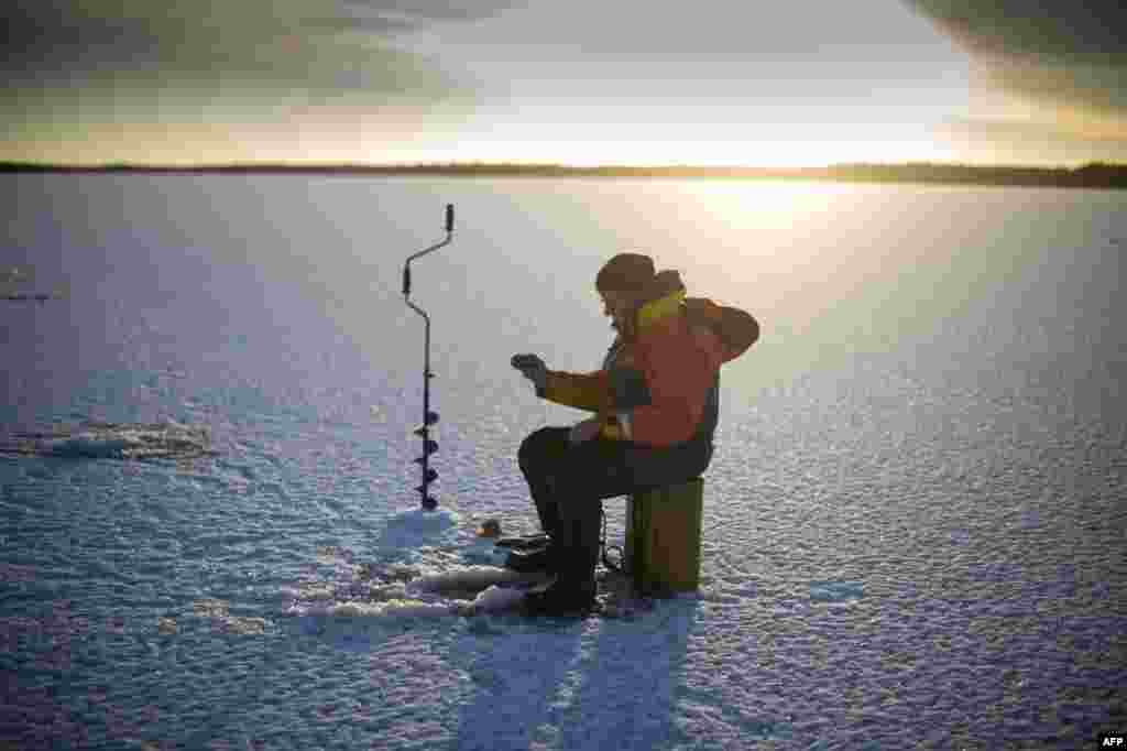 A man ice-fishes on the frozen Bothnia Sea in Vaasa, Western Finland, Dec. 28, 2016.