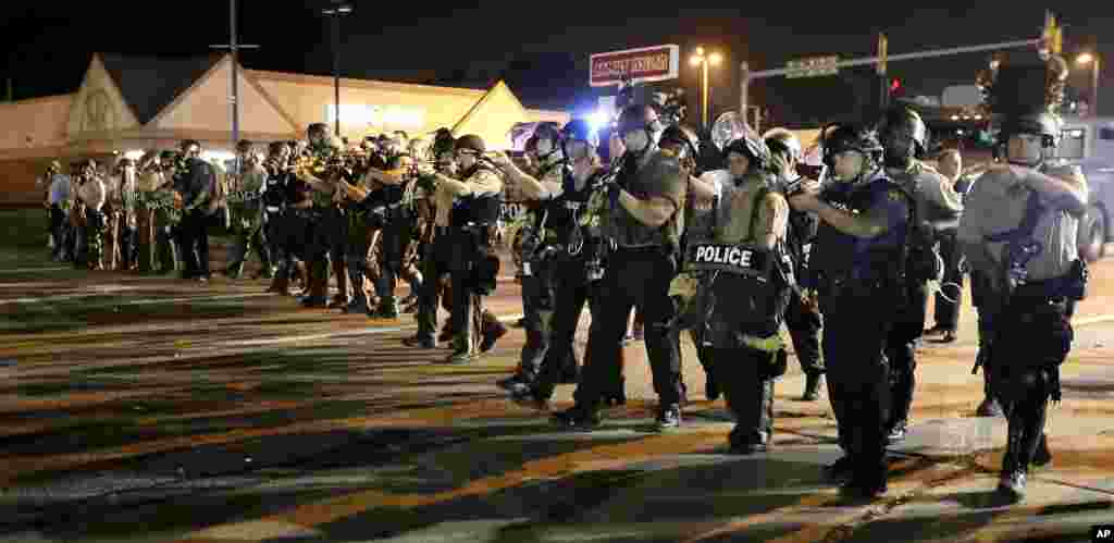 Polisi bergerak maju untuk membubarkan kerumunan orang dalam sebuah demonstrasi mengenang Michael Brown, Ferguson, Missouri, 18 Agustus 2014.