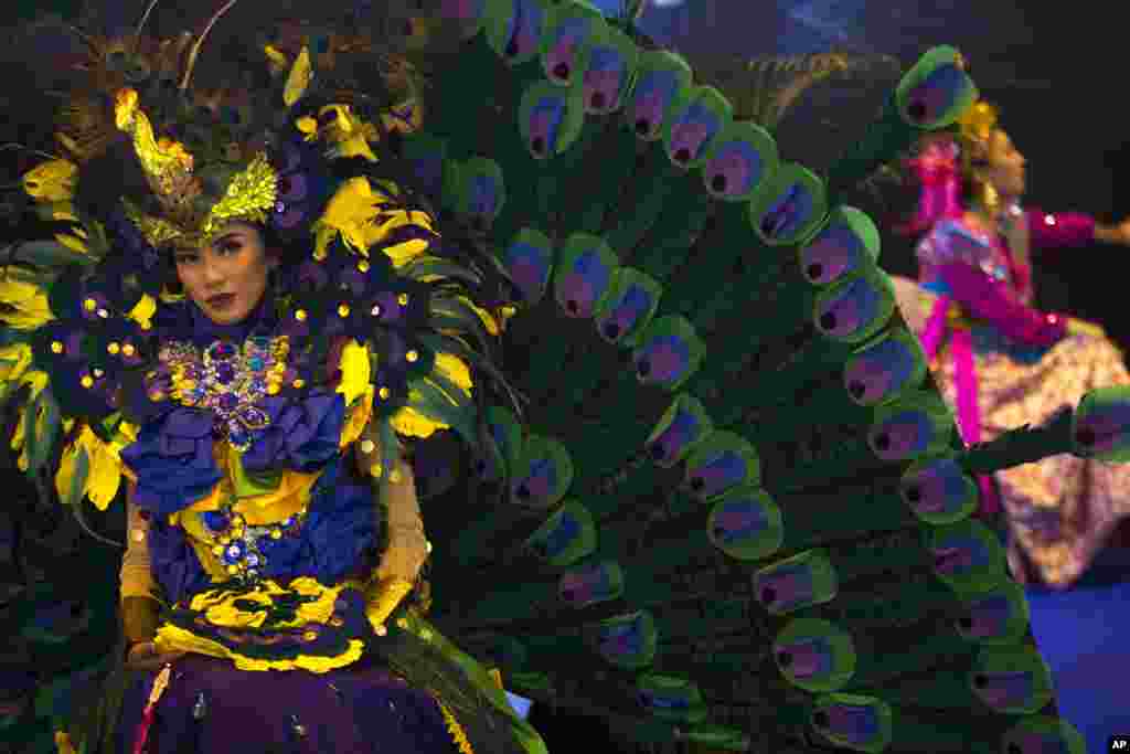 A woman wearing a colorful Indonesian costume poses for photographs at the Indonesia stand during the &quot;FITUR&quot; International Tourism Fair in Madrid.