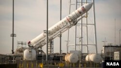 The Orbital Science Corporation Antares rocket is seen as it is raised into position at launch Pad-0A at NASA's Wallops Flight Facility, Wallops Island, Virginia, Dec. 17, 2013.