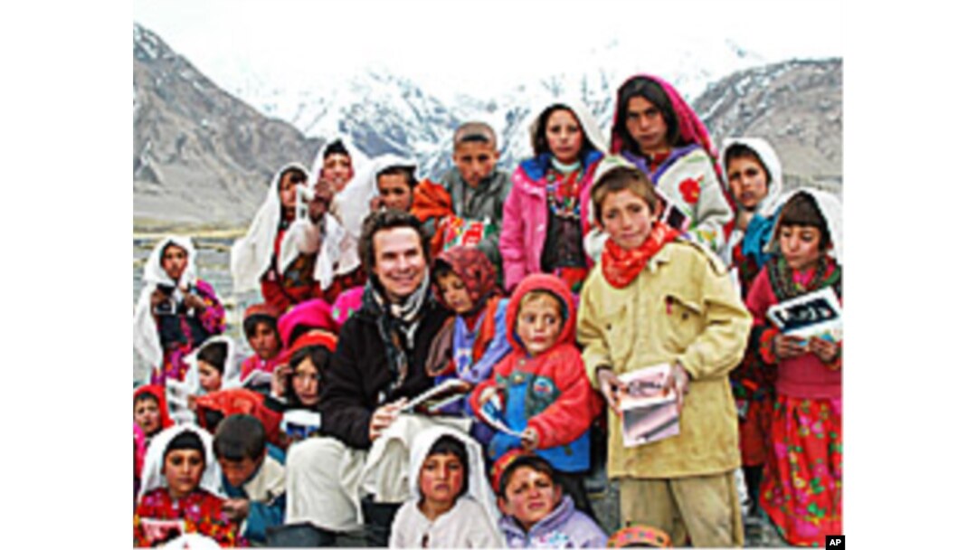 Greg Mortenson poses with schoolchildren in Afghanistan.