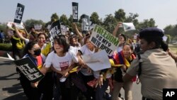 An Indian policewoman tries to prevent Tibetan exiles from reaching the Chinese embassy during a protest in New Delhi, India, March 10, 2015.