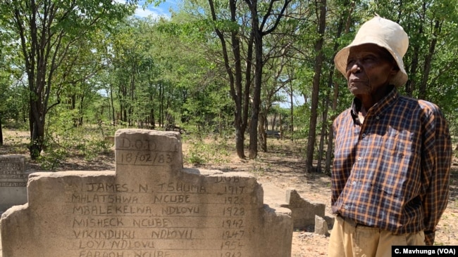 Melwa Ngwenya stands near a grave holding the remains of his son Sibangani, killed in February 1983 in Tsholotsho, Zimbabwe. Ngwenya seeks compensation for the state-sanctioned massacres known as Gukurahundi.