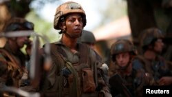 FILE - French soldiers stand in front of protesters demonstrating against French troops in Bambari, Central African Republic.