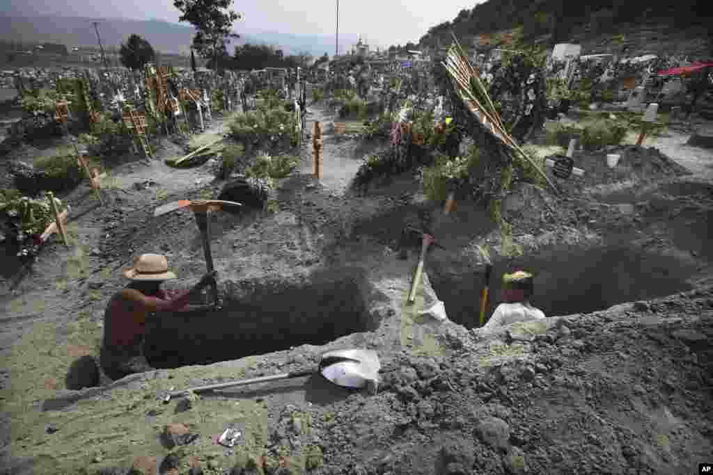 Men dig graves at the Valle de Chalco cemetery during the new coronavirus pandemic on the outskirts of Mexico City, March 31, 2021.