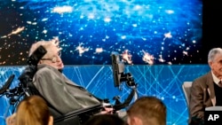 Stephen Hawking, left, is joined by a group of of scientist including Princeton physicist Freeman Dyson, right, announce the new Breakthrough Initiative focusing on space exploration and the search for life in the universe, during a press conference, Tuesday, April 12, 2016, at One World Observatory in New York. (AP Photo/Bebeto Matthews)