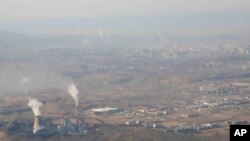 Asap dan uap mengepul dari menara di Pembangkit Listrik Tenaga Panas Urumqi berbahan bakar batubara di Urumqi di Daerah Otonomi Uyghur Xinjiang China barat, 21 April 2021. (Foto: AP)