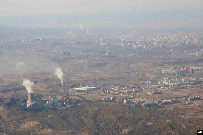 Asap dan uap mengepul dari Pembangkit Listrik Tenaga Panas Urumqi di Urumqi di Daerah Otonomi Uyghur Xinjiang China barat, 21 April 2021. (Foto: AP)