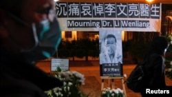 资料照：人们戴着口罩出席在香港设立的一处悼念在武汉中心医院病逝的李文亮医生。（2020年2月7日）