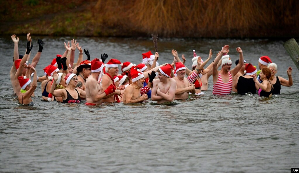 Members of the Berliner Seehunde (Berlin seals) swimming club take a bath at the lake Oranke during their traditional Christmas swim in Berlin, Germany, Dec. 25, 2017.