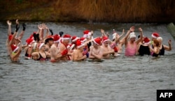 Members of the Berliner Seehunde (Berlin seals) swimming club take a bath at the lake Oranke during their traditional Christmas swimm in Berlin, Germany, Dec. 25, 2017.