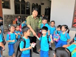 Para murid SD BPK Penabur memberikan tanaman sebagai tanda mata kepada Sonny Hermawan, perwakilan gereja Katolik St. Mikael, Bandung, Jumata, 15 November 2019. (Foto: Rio Tuasikal/VOA)