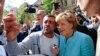 Kanselir Jerman Angela Merkel disambut meriah oleh pengungsi Suriah dan dijuluki 'Mama Merkel' saat berkunjung ke pusat registrasi migran di distrik
Spandau, Berlin hari Kamis (10/9).