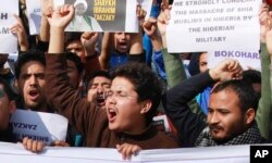 FILE - Muslims students carry placards and shout slogans against the Nigerian government and the killings of hundreds of Shiite Muslims in Jammu, India, Dec. 15, 2015.