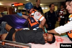 An injured man receives treatment at the Beersheba central bus station, where a Palestinian gunman went on a stabbing and shooting rampage, Oct. 18, 2015.