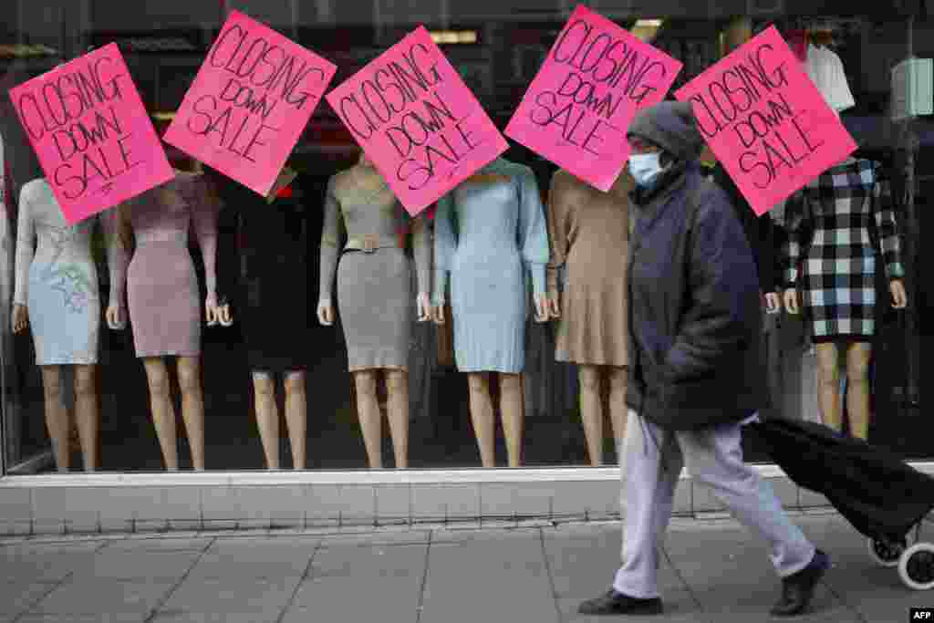 A pedestrian walks past &quot;Closing Down Sale&quot; signs in the window of a clothes shop in Walthamstow, east London. The UK government announced a &#163;9 billion package to offset soaring energy bills.