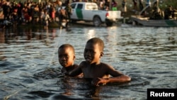 FILE PHOTO: Children seeking asylum in the U.S. grab onto a rope to guide them through the current while crossing the Rio Grande river into Mexico near the International Bridge between Mexico and the U.S. in Ciudad Acuna, Mexico, September 20, 2021. ( REUTERS/Go Nakamura/File)