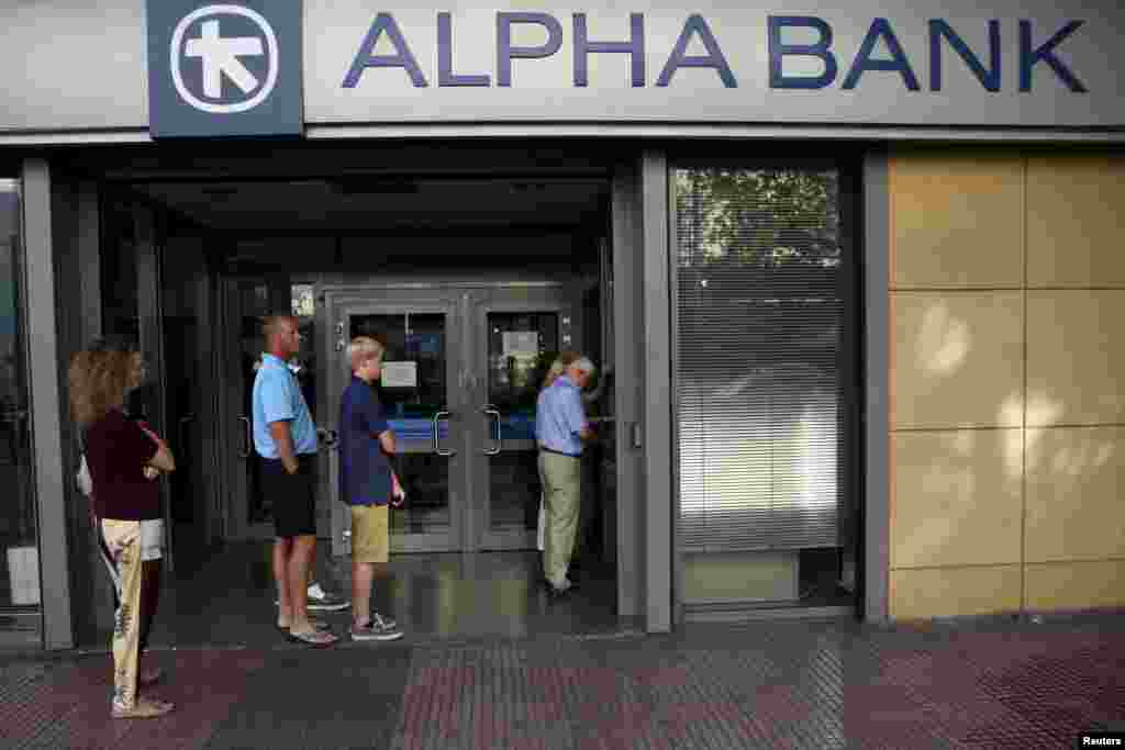 People line up at an ATM outside an Alpha Bank branch in Athens, July 15, 2015.&nbsp;