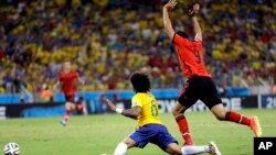 Mexico's Raul Jimenez, right, raises his arms after a challenge on Brazil's Marcelo during the group A World Cup soccer match between Brazil and Mexico at the Arena Castelao in Fortaleza, Brazil, Tuesday, June 17, 2014