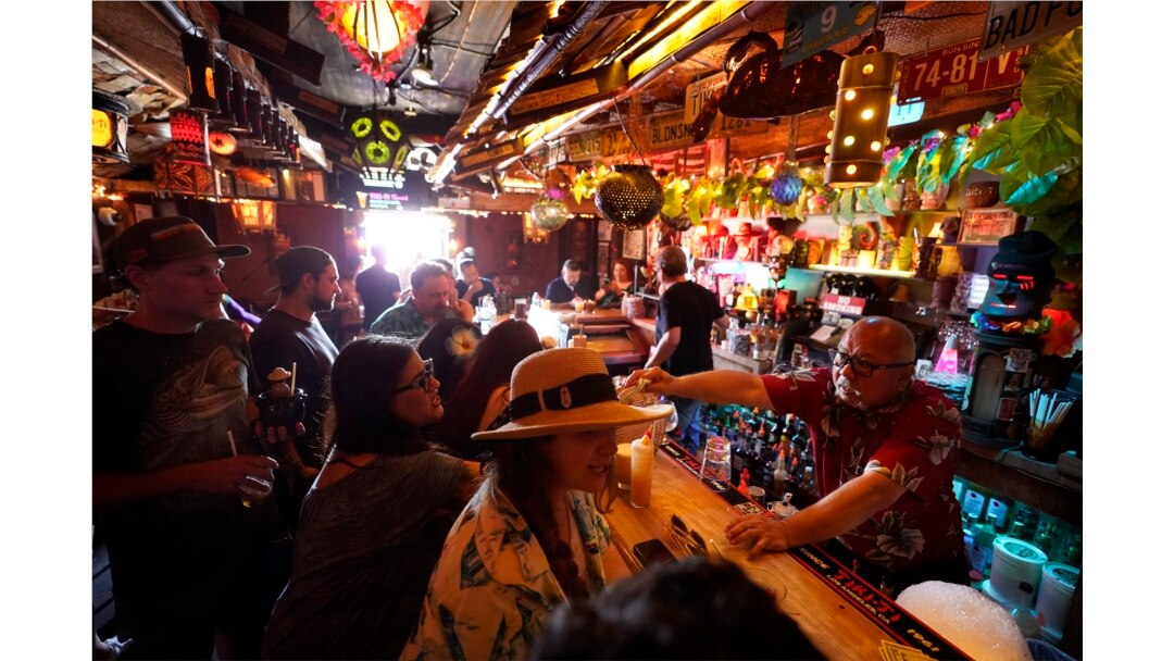 Para pengunjung menikmati minuman di bar yang baru dibuka kembali setelah lockdown COVID-19 di Sunset Boulevard di Los Angeles, 7 Juli 2021. (Foto: Damian Dovarganes/AP)