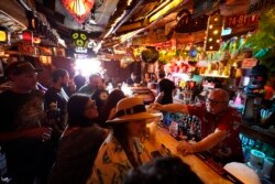 Para pengunjung menikmati minuman di bar yang baru dibuka kembali setelah lockdown COVID-19 di Sunset Boulevard di Los Angeles, 7 Juli 2021. (Foto: Damian Dovarganes/AP)