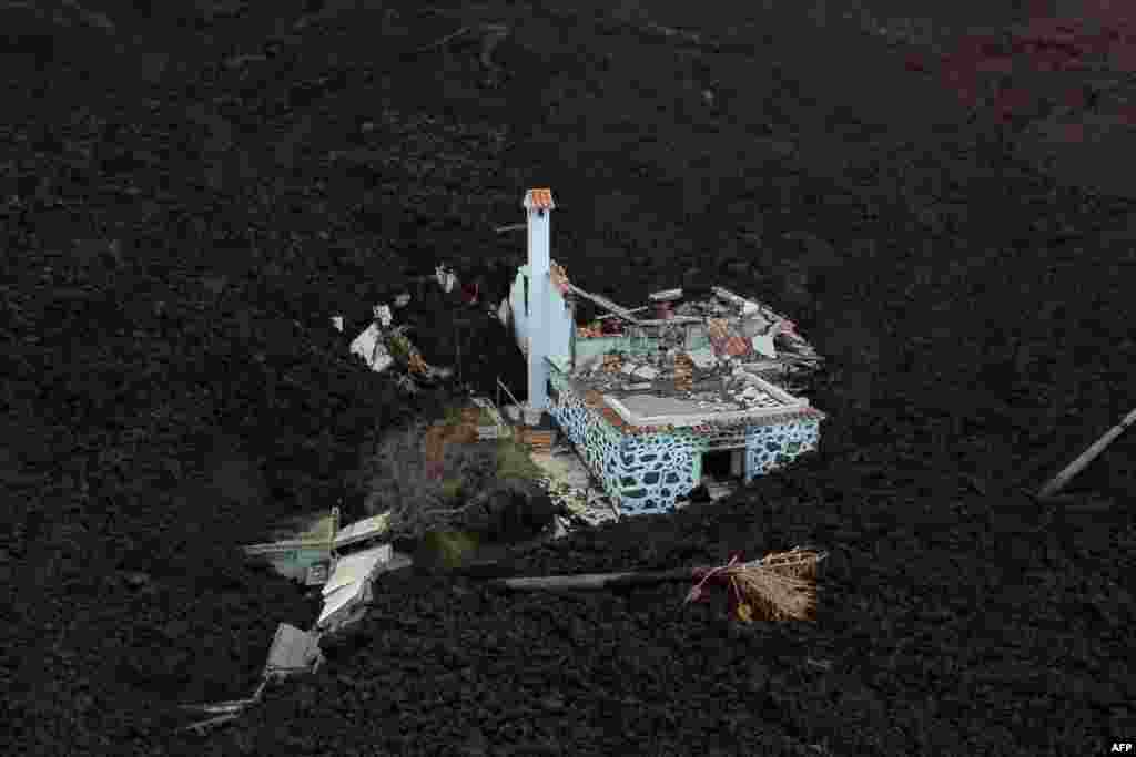 This aerial picture shows a destroyed house covered with lava following the eruption of the Cumbre Vieja volcano, in La Laguna, on the Canary Island of La Palma.