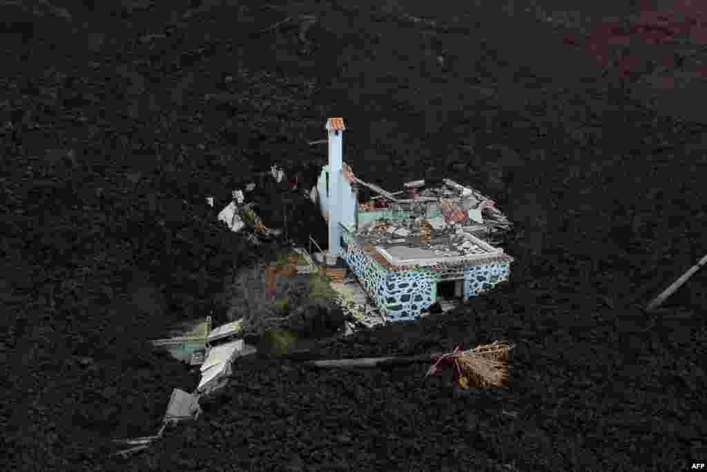 This image from above shows a destroyed house covered with lava following the burst of the Cumbre Vieja volcano, in La Laguna, on the Canary Island of La Palma.