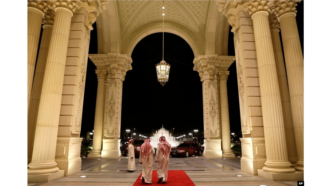 FILE - Saudi men walk at the entrance to the Ritz-Carlton Hotel, in Riyadh, Saudi Arabia, March 4, 2013. Dozens of elite detainees are reportedly being held in a well-guarded ballroom of the hotel as part of a sweeping corruption probe.