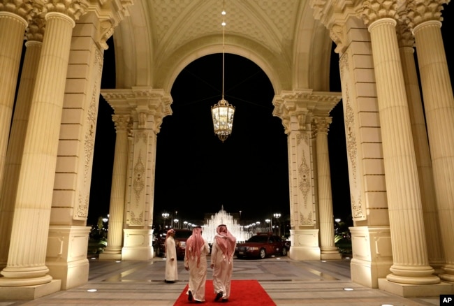 FILE - Saudi men walk at the entrance to the Ritz-Carlton Hotel, in Riyadh, Saudi Arabia, March 4, 2013. Dozens of elite detainees are reportedly being held in a well-guarded ballroom of the hotel as part of a sweeping corruption probe.