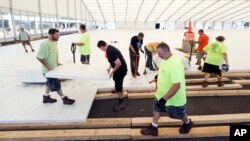 Workers assemble flooring in Temporary structures outside the Wells Fargo Center ahead of the the 2016 Democratic National Convention in Philadelphia, June 22, 2016. (AP Photo/Matt Rourke)