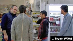 Des migrants afghans discutent avec un employé turc dans un supermarché halal à Reims.