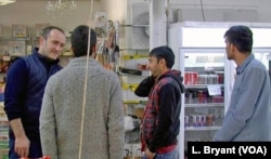 Afghan migrants chat with a Turkish employee at a Halal supermarket in Reims.