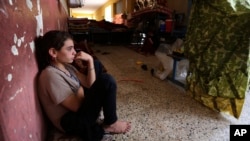 An internally displaced Yazidi who fled from an Iraqi town after advances by Islamic militants takes shelter at a school in Dahuk, 260 miles (420 kilometers) northwest of Baghdad, Thursday, Oct. 2, 2014. 