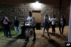 Hassan Chami, banging a bass drum, leads attendees to the Ramadan Suhoor Festival in Dearborn Heights, Mich.