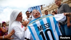 Une religieuse tient un maillot portant le numéro de Leonel Messi, sur la place St.-Pierre du Vatican (13 juillet 2014).