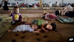 Syrian refugee children try to amuse themselves at a camp near the Turkish border in August of last year.