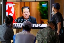 Orang-orang menonton layar TV yang menampilkan pemimpin Korea Utara Kim Jong Un dalam sebuah program berita, di Stasiun Kereta Api Seoul di Seoul, Korea Selatan, 30 September 2021. (Foto: Associated Press)