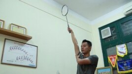 In this March 19, 2020, photo, a PE teacher demonstrates a badminton technique to his students during an online class at Nguyen Tat Thanh school in Hanoi, Vietnam. (AP Photo/Hau Dinh)