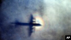FILE - In this March 31, 2014 file photo, the shadow of a Royal New Zealand Air Force P3 Orion is seen on low level cloud while the aircraft searches for missing Malaysia Airlines Flight MH370.