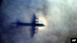 FILE - In this March 31, 2014 file photo, the shadow of a Royal New Zealand Air Force P3 Orion is seen on low level cloud while the aircraft searches for missing Malaysia Airlines Flight MH370 in the southern Indian Ocean, near the coast of Western Australia. 