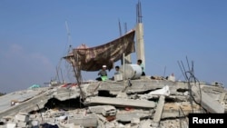 8月13日一群巴勒斯坦儿童坐在他们住房的废墟上