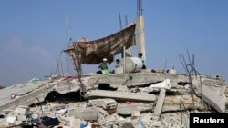 8月13日一群巴勒斯坦儿童坐在他们住房的废墟上