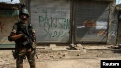 FILE - A Pakistani soldier stands in front of closed shops during a military operation against Taliban militants in the town of Miranshah in North Waziristan, July 9, 2014. 