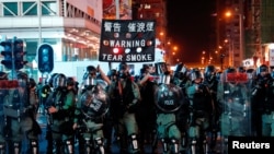 Polícia de choque usa um cartaz a alertar manifestantes que vai usar gás lacrimogéneo contra os manifestantes anti-governo em Hong Kong, 20 Outubro, 2019.
