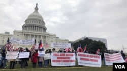 Protestors hold banners in front of Capitol Hill. (Chetra Chap/VOA Khmer) 