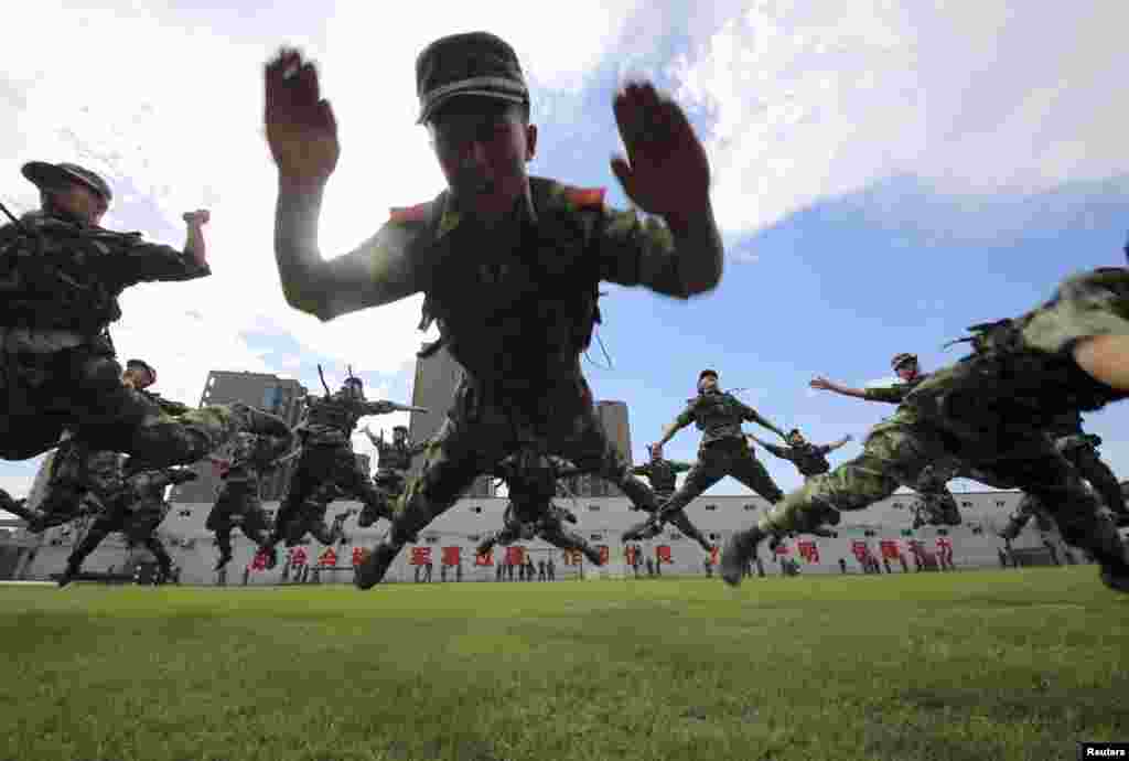 Paramilitary policemen jump as they practice during a summer drill in Hangzhou, Zhejiang province, China.